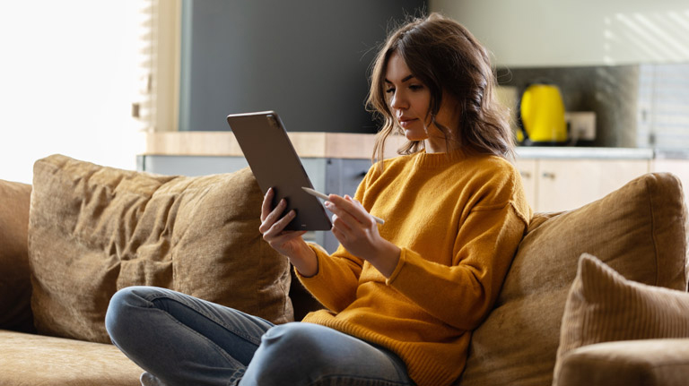 women on her tablet on the couch